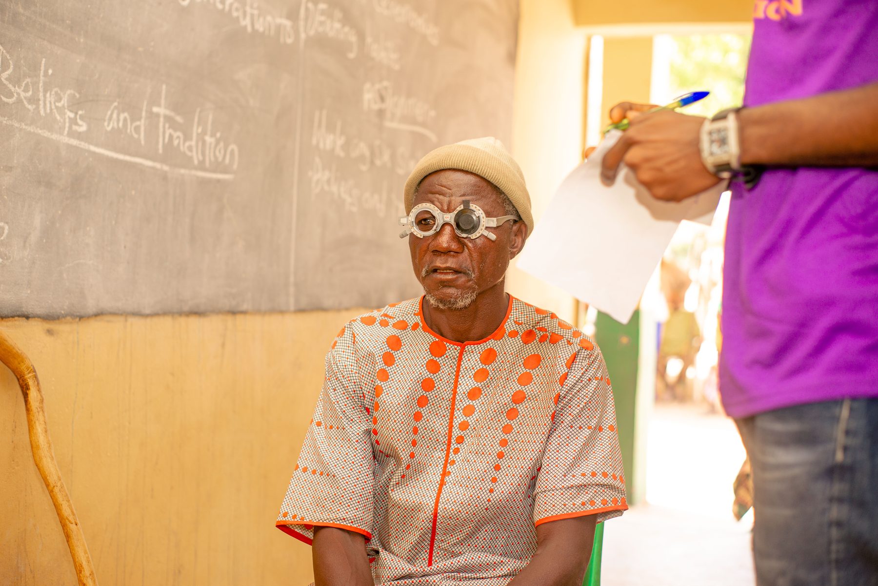An elderly community member receiving a vision test during an outreach