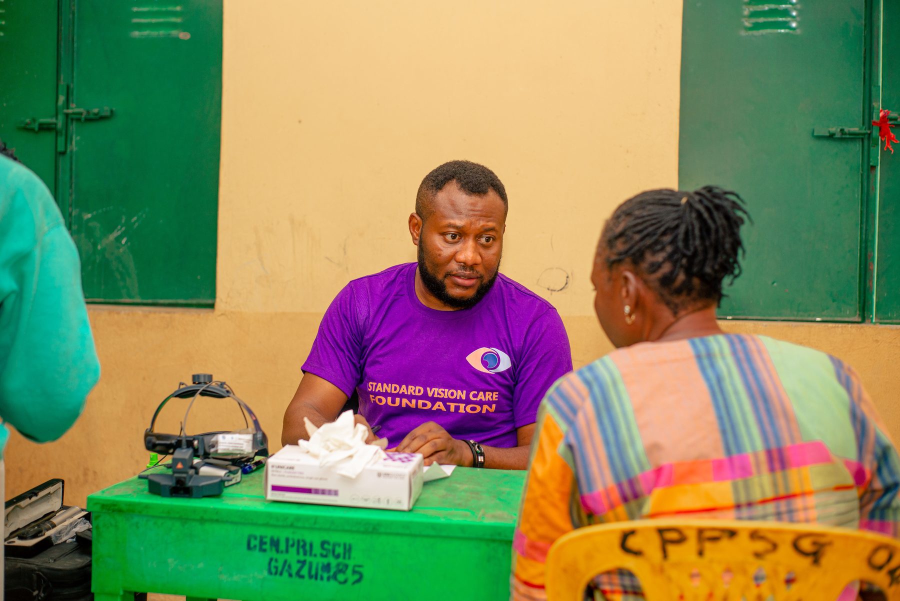 Foundation volunteer speaking with a patient at an eye screening